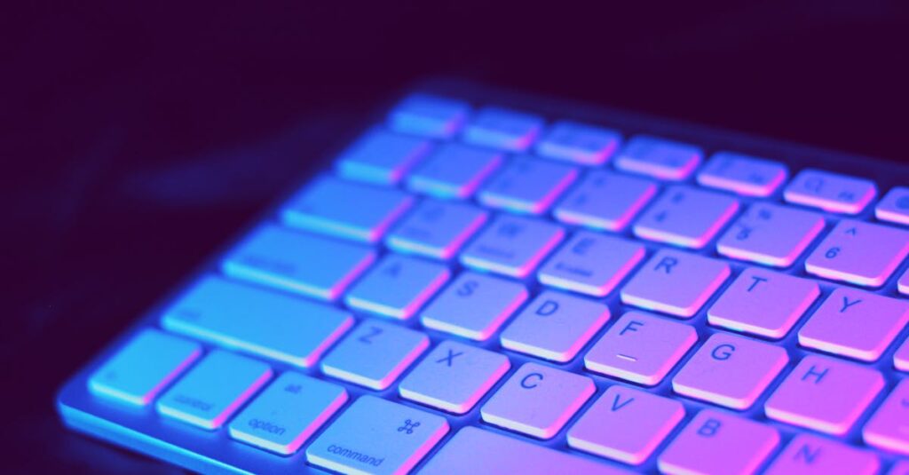 pexels photo 1309766 1309766 Close-up of a modern keyboard illuminated with vibrant purple and blue neon lighting.